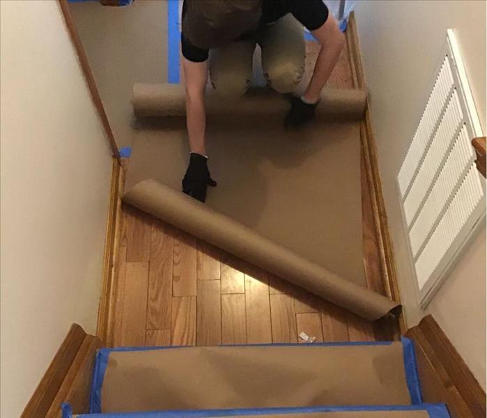 Brown paper taped to hardwood floor and steps