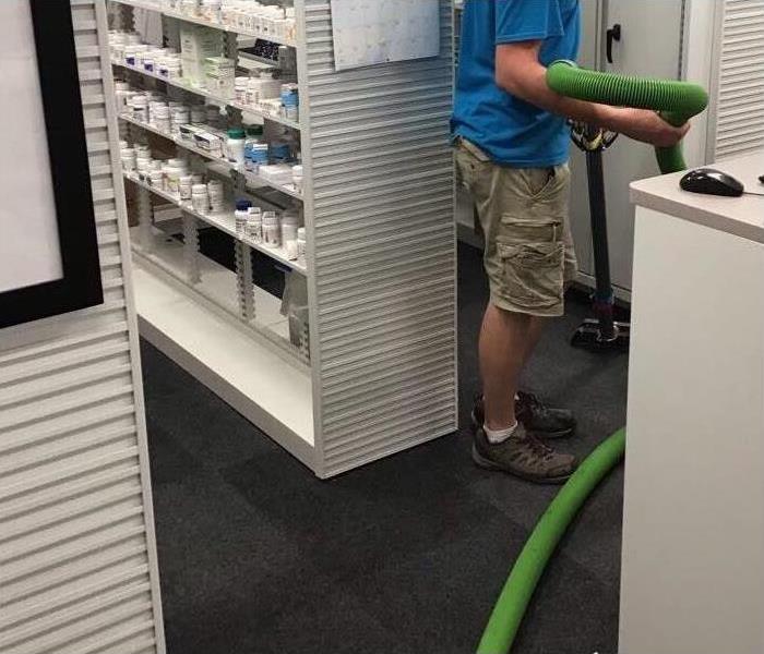 SERVPRO employee removing water from local pharmacy
