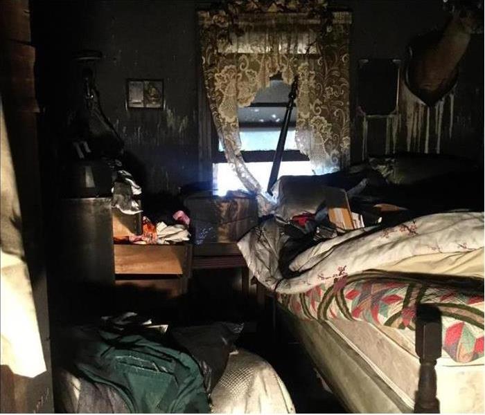 Image of a bedroom covered in soot and smoke damage after a severe fire