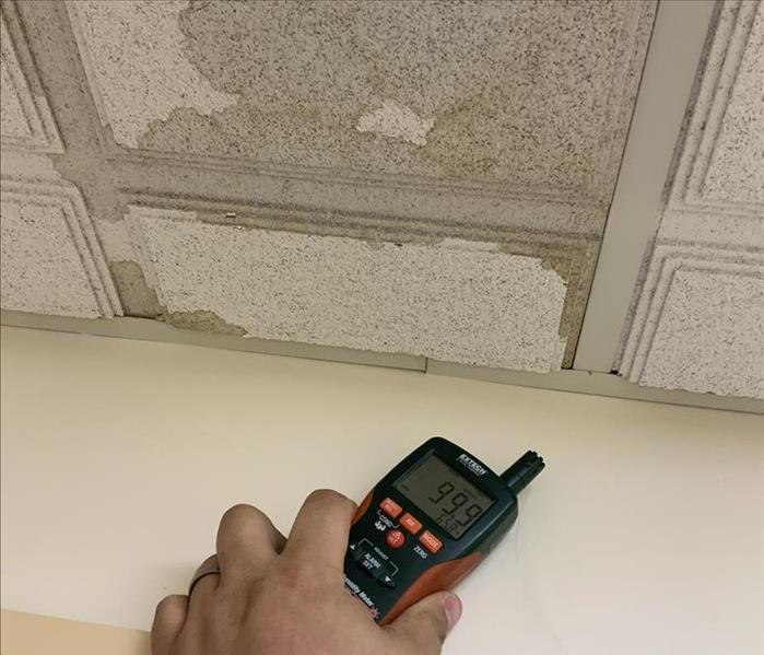 Moisture meter on white dry wall 