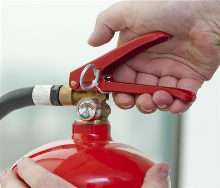 Image of a person holding a fire extinguisher