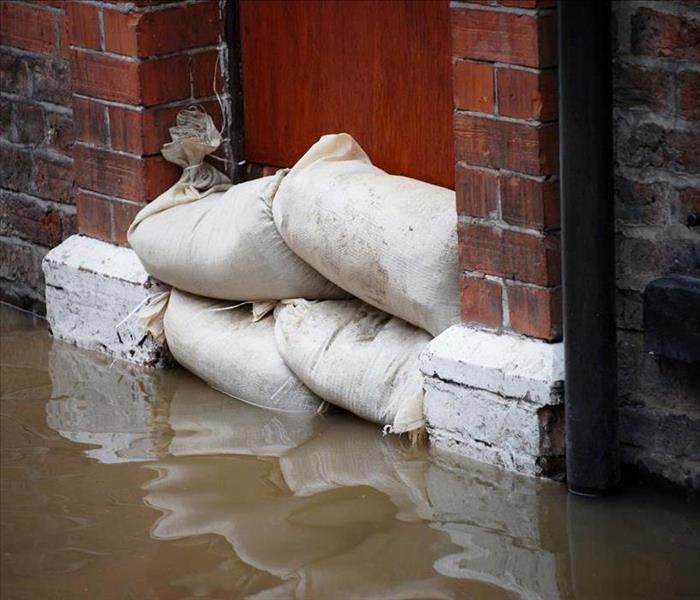 Image of sandbags placed on door to block water from entering a building. 